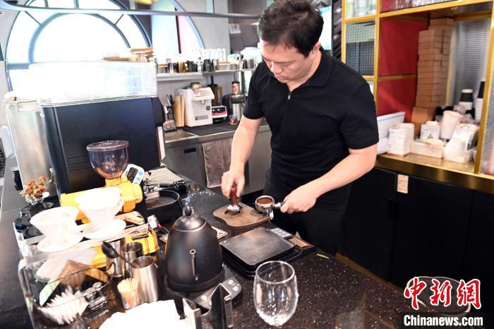 图为张元亨在咖啡馆里制作咖啡。　蒋雪林 摄