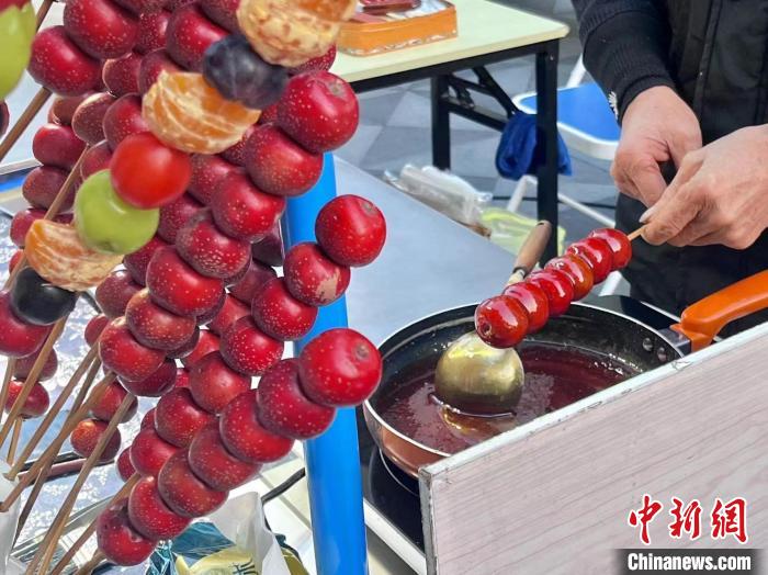 武林夜市摊主正在制作冰糖葫芦。　汪轶文 　摄